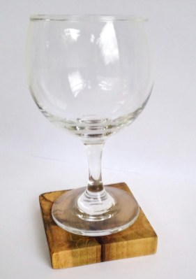 rustic wood coaster under a clear glass wine glass