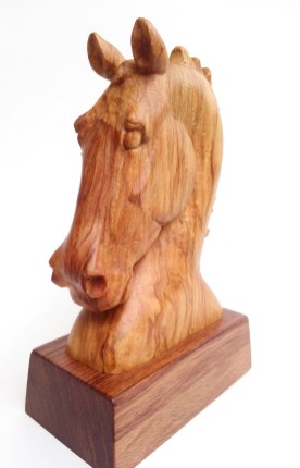 horse head carving on small stand, facing forward at an angle so you see the left side of the horse's face and the front.