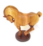 hand carved stylized wood carving of horse on circular walnut stand
